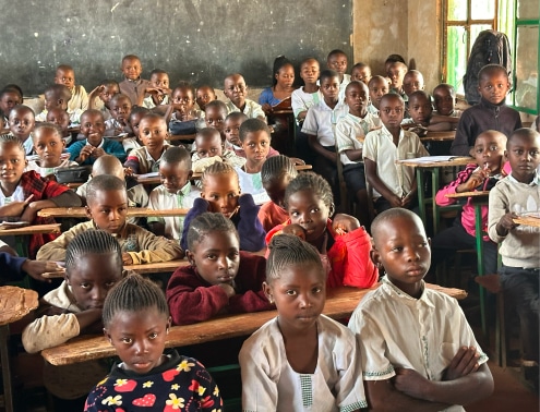 Many school children in a classroom looking at the camera in Democratic Republic of the Congo